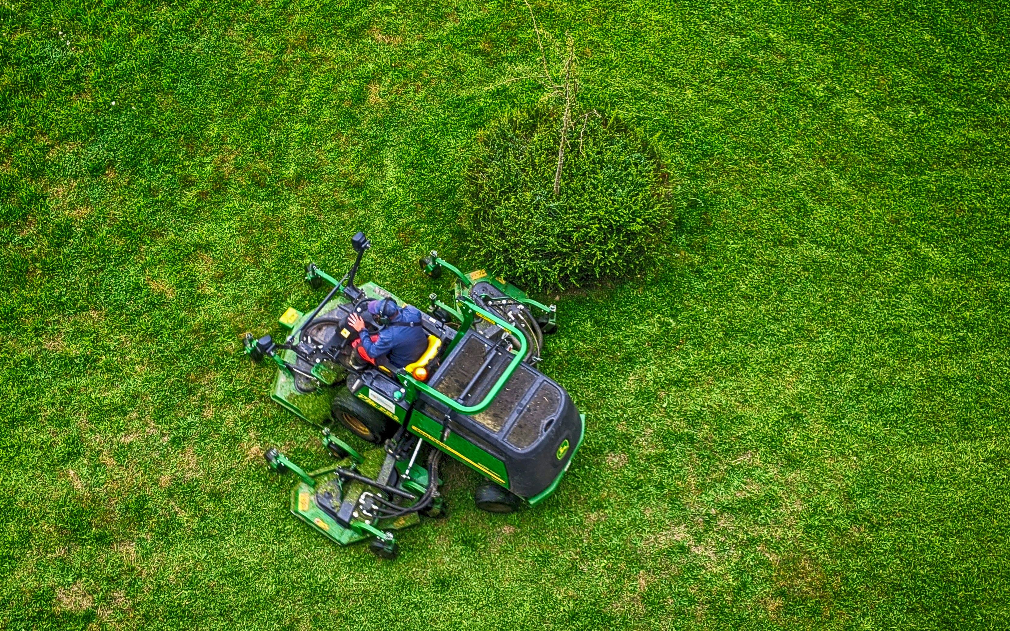 Aerial view of a Shamrocks & Stallions operator mowing a lush green lawn